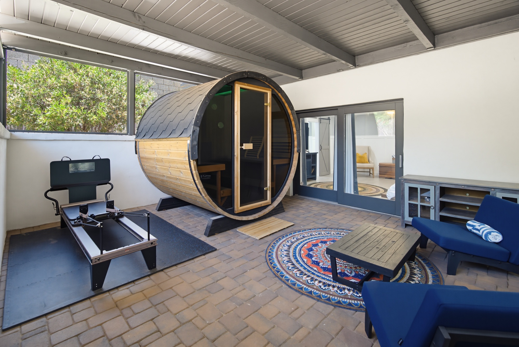 Wellness room with barrel sauna and fitness equipment